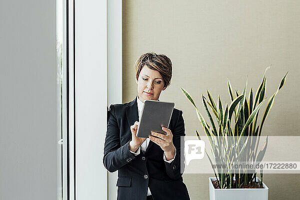 Geschäftsfrau bei der Arbeit an einem digitalen Tablet im Büro