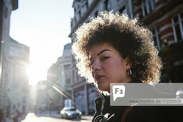 Curly haired woman during sunny day in city