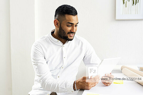 Businessman using digital tablet on desk at office