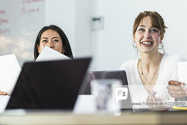 Geschäftsfrau lächelt bei einem Kollegen im Büro