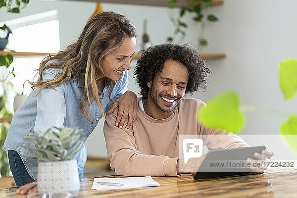 Geschäftsmann und Frau schauen gemeinsam auf ein digitales Tablet