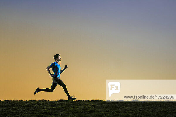 Sportsman jogging with dedication during sunset