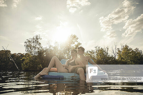 Junges Paar sitzt auf einem Boot auf dem See und entspannt sich