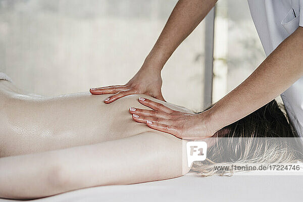 Female therapist massaging patient in clinic