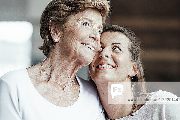 Smiling woman looking at contemplating grandmother at home