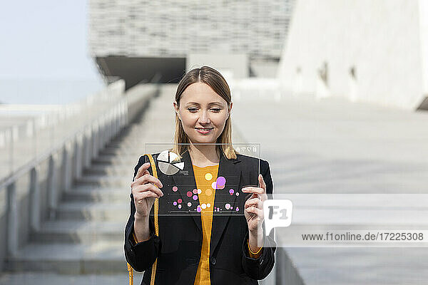 Female entrepreneur working over glass digital tablet outdoors