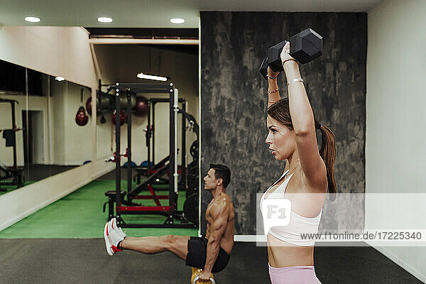 Männliche und weibliche Athleten trainieren mit Geräten im Fitnessstudio