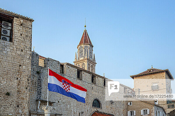 Kroatien  Gespanschaft Split-Dalmatien  Trogir  kroatische Flagge vor alten Stadthäusern mit Glockenturm der Kirche des Heiligen Nikolaus im Hintergrund