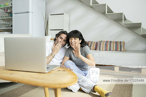 Reifes Paar gestikuliert während eines Videoanrufs auf dem Laptop zu Hause