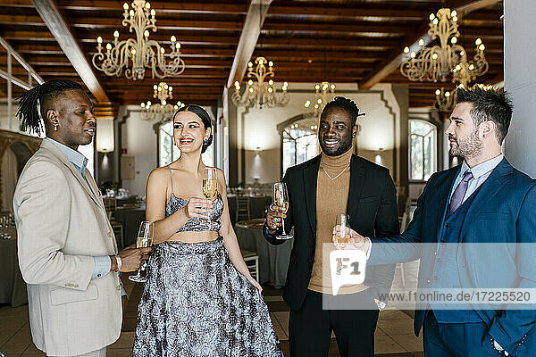 Elegante Männer und Frauen halten Champagnerflöten bei einem Bankett