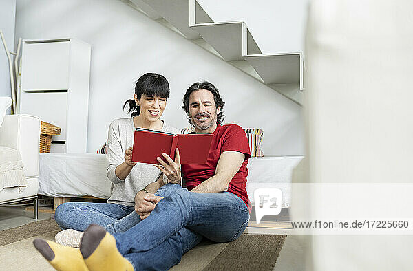 Mature couple looking at photo album while sitting at home