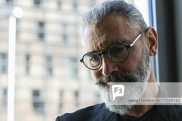 Thoughtful businessman with eyeglasses in coffee shop