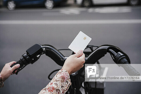 Frau benutzt Kreditkarte  um in der Stadt ein Fahrrad zu mieten