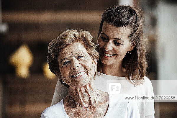 Lächelnde junge Frau schaut auf glückliche Großmutter