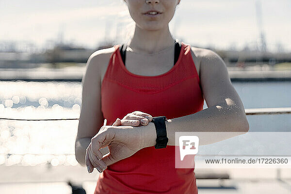 Female jogger checking fitness progress on smart watch