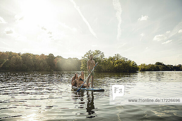Friends enjoying summer on the lake  paddling on a paddleboard