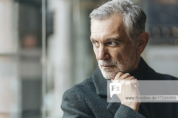 Thoughtful man with hand on chin looking away
