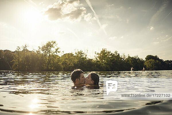 Zärtliches Paar schwimmt zusammen in einem See