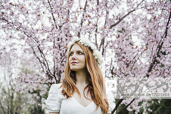 Schöne Frau mit weißem Blumen-Diadem schaut weg