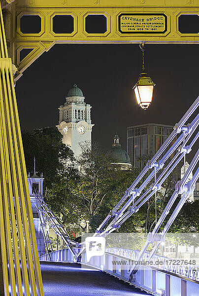 Singapur  Cavenagh-Brücke bei Nacht mit Uhrenturm des Victoria Theatre und der Concert Hall im Hintergrund