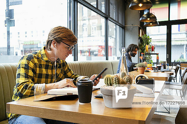 Young businessman using smart phone while working in coworking office