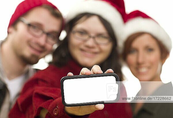 Girl with friends and santa hats holding blank white smart phone  ready for your own message