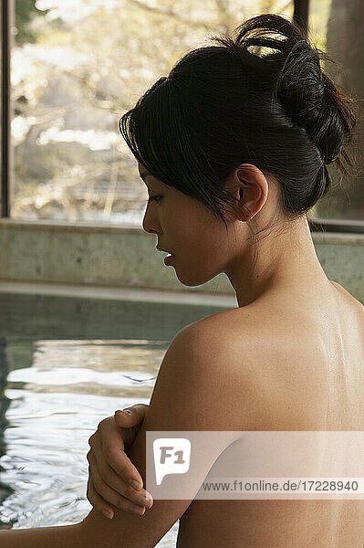 Serene nackte junge Frau Einweichen im Pool bei Onsen