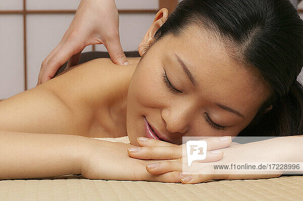 Close up serene young woman receiving massage in spa