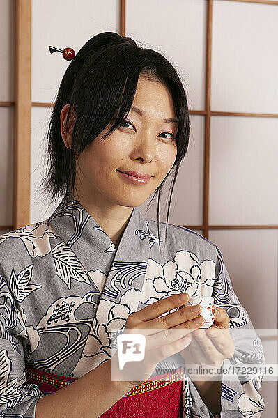 Portrait beautiful young woman in Japanese kimono with tea