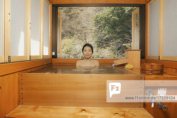 Porträt schöne junge Frau Einweichen im Pool bei japanischen Onsen
