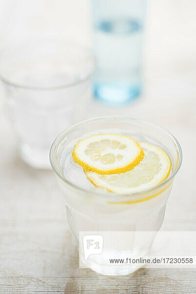 Frisches Wasser mit Eiswürfeln und Zitronenscheibe im Glas