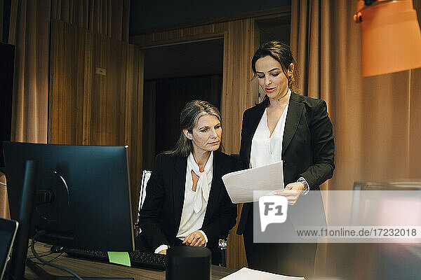 Businesswoman discussing over document with female lawyer at office