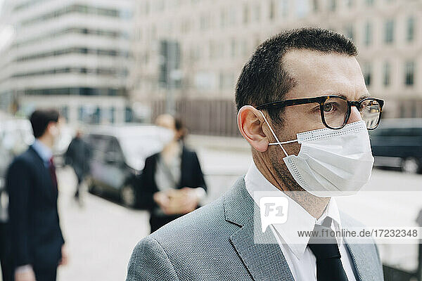 Älterer Geschäftsmann mit Gesichtsschutzmaske in der Stadt