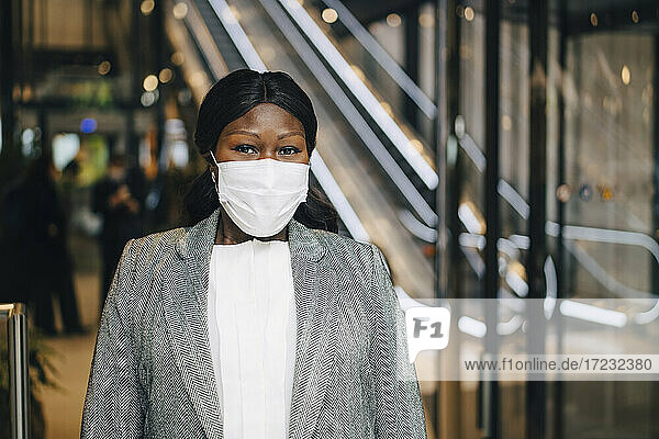 Reife Unternehmerin mit Gesichtsschutzmaske an der U-Bahn-Station