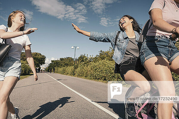 Fröhliche Freundinnen genießen beim Radfahren auf der Straße