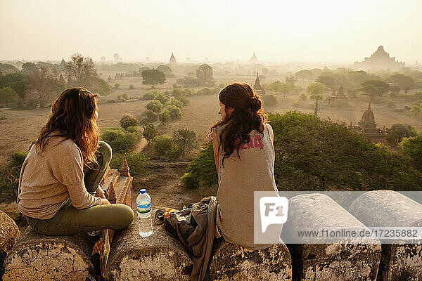 Women relaxing on stone wall  Bagan Archaeological Zone  Buddhist temples  Mandalay  Myanmar