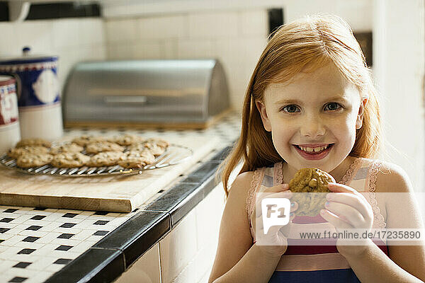 Porträt von Mädchen essen Keks in der Küche