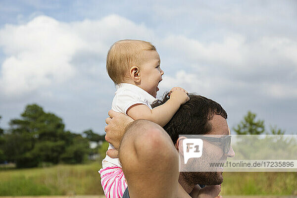 Mid erwachsenen Mann trägt Baby Tochter auf den Schultern