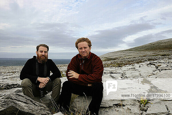 Zwei Männer sitzen auf Felsen  The Burren  County Clare  Irland