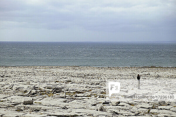 Mann am felsigen Ufer  The Burren  County Clare  Irland