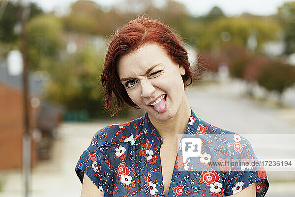 Young woman with red hair  sticking her tongue out