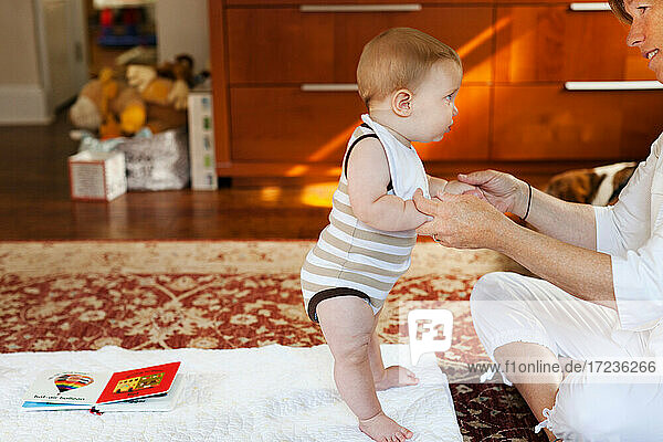 Mutter und Baby Sohn spielen auf Teppich