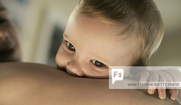 Baby-Junge im Arm der Mutter gewiegt