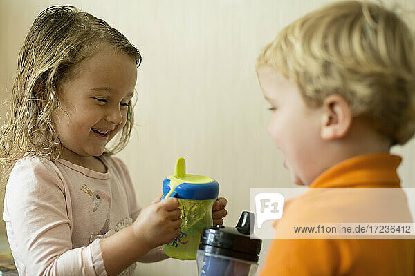 Male and female toddler friends having a drink