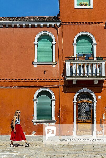 Junge Frau vor bunten Häusern  farbenprächtige Häuserfassaden  Insel Burano  Venedig  Venetien  Italien  Europa