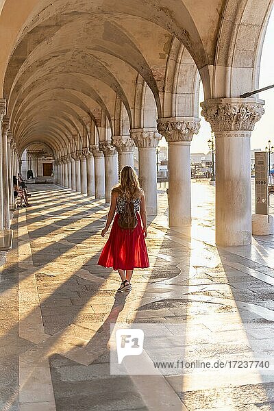 Junge Frau im Säulengang am Dogenpalast  am Markusplatz  Venedig  Venetien  Italien  Europa