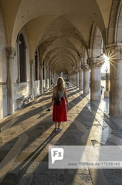 Junge Frau im Säulengang am Dogenpalast  am Markusplatz  Venedig  Venetien  Italien  Europa