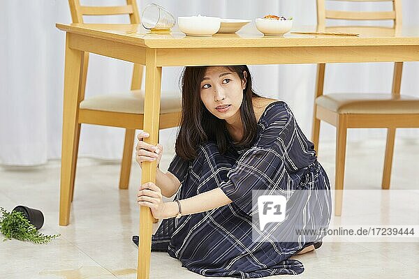 Japanerin kniet während des Erdbebens unter einem Tisch