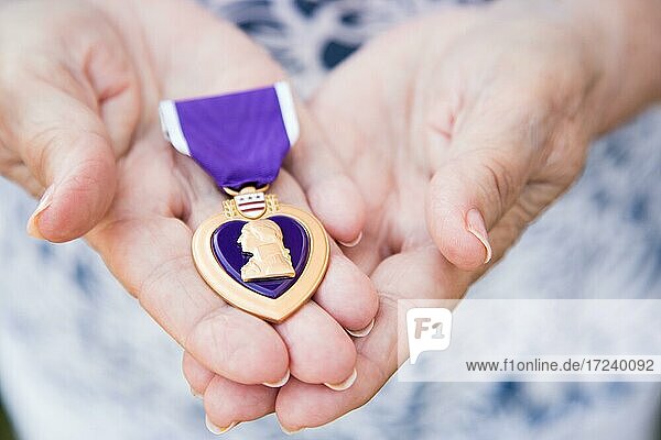 Ältere Frau hält die United States Military Purple Heart Medaille in ihren Händen