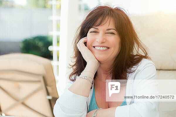 Attraktive Frau mittleren Alters lächelt auf der Veranda